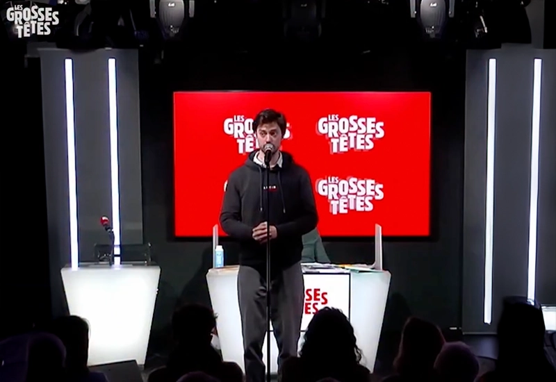 Félix Radu debout au centre du plateau des Grosses Têtes sur RTL